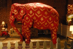 Eine Kunstaktion von Bansky zeigt einen echten lebendigen und rot angemalten Elefanten im Raum